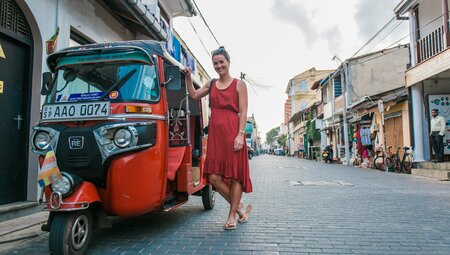 Traveller standing next to a tuk-tuk in Unawatuna, Sri Lanka on an Intrepid Travel tour