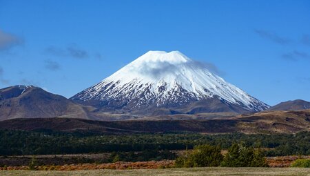 Wide view of Mount Ruapehu against a blue sky backdrop in Tongariro National Park, New Zealand