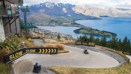 Travellers speeding downhill on luges in Queenstown, New Zealand
