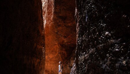 Younger Intrepid traveller looking up in the smooth curling walls of Echidna Chasm in the Kimberley