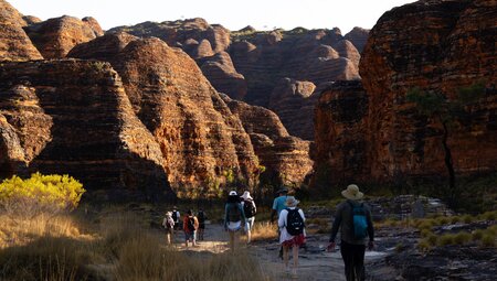 Intrepid travellers walking into the domes of the Bungle Bungle Range in Western Australia