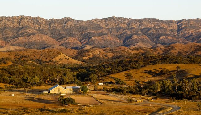 Aerial view of the woolshed accomodation facilities in vast, red landscape during sunset, South Australia