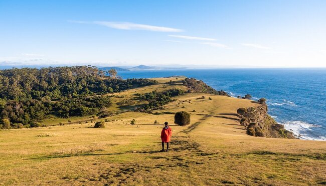 Traveller walking a path on the coastal landscape of Maria Island, Australia