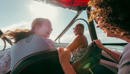 Three travellers laugh together on the boat travelling to snorkel in Port Douglas