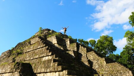 Intrepid traveller celebrates atop the Mayan pyramid of Yaxha Nakum Naranjo National Park