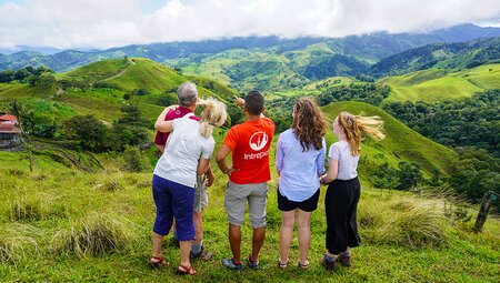 Intrepid travellers and leader look out at a beautiful hill landscape near Monteverde, Costa Rica