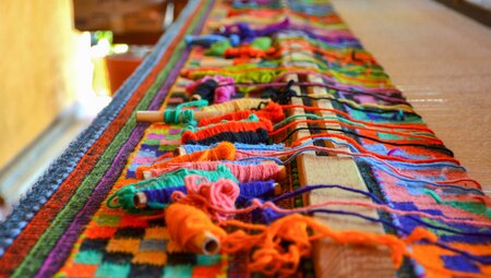 Teotitlan del Valle weaving setup with complex layout of spools of yarn