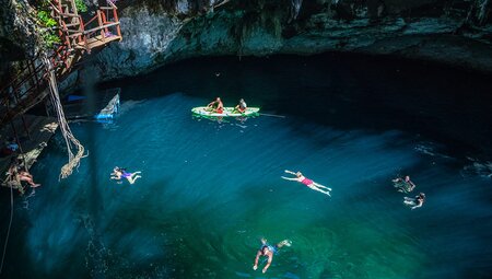 Travellers swimming in hate Cenotes, Mexico