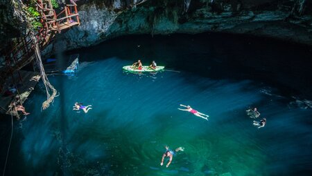 High POV of travellers enjoying a cenote, swimming and in boats, Mexico