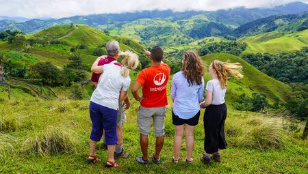 Leader points to elements of hill landscape in Monteverde Costa Rica