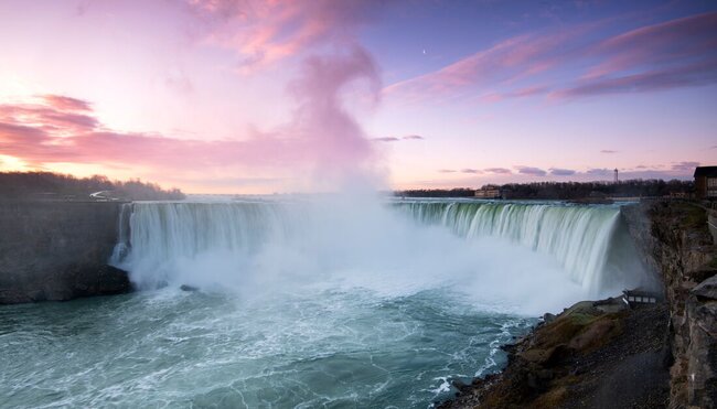 Gentle mist drifts off Niagara Falls at sunset in southern Canada
