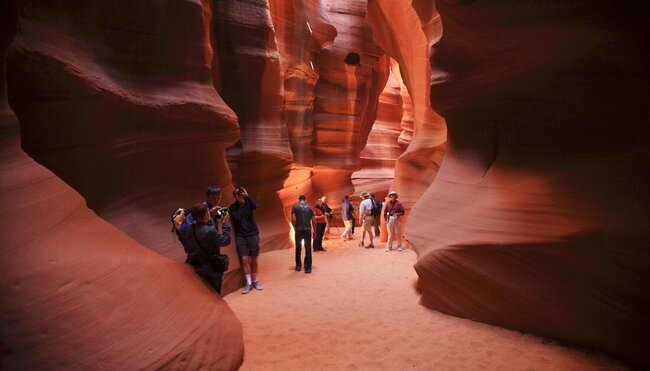 Travellers walking through rock formations in Antelope Canyon, Arizona, USA