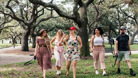Group with leader in red hat walk around Charleston's parks with happy smiles