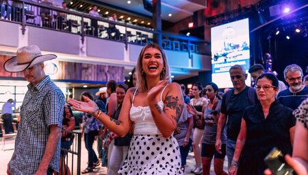 Travellers dances and claps happily at a bar in nashville during a dancing lesson