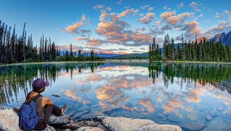 Traveller enjoys sunrise over Pyramid Lake in Jasper National Park Canada