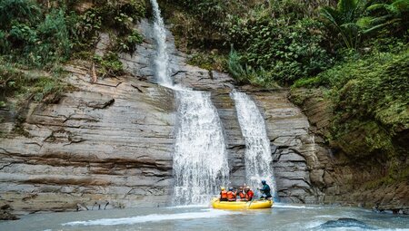 Travellers on raft in front of a waterfall in Navua River, Fiji