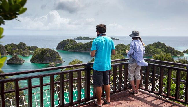 Travllers taking in the view of Piaynemo Islands in Indonesia