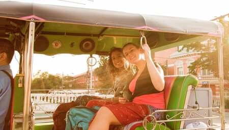 Travellers enjoy a tuk-tuk ride in the afternoon in Bangkok