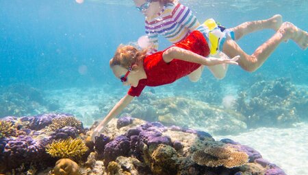 Family fun snorkeling at coral reef, Borneo