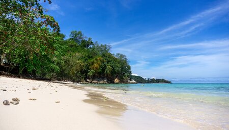 Crystal clear ocean water rolls onto Manukan Island beach off the coast of Borneo