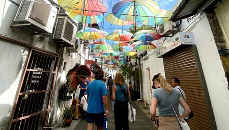 Group of travellers going on orientation walk through the colourful streets of Georgetown, Penang