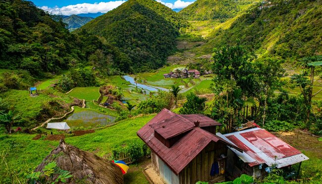 Iron sheet rooved homes of Bangaan village in foreground and distance in the midst of layered rice terraces