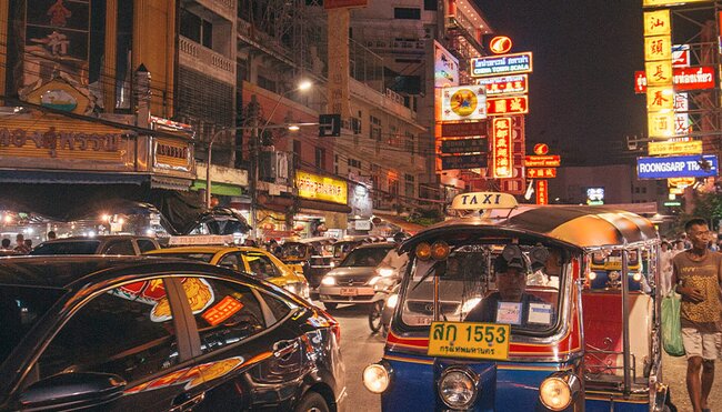 Street view of the hustle and bustle of Bangkok lit up at night