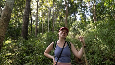 Traveller smiling with lush green forest behind them on a hilltribe trek, Mae Taeng District, Chiang Mai, Thailand