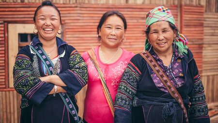 Locals in traditional dress smile and pose for camera
