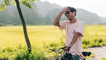Traveller fixes hair after a long bicycle ride in the countryside of Ninh Binh