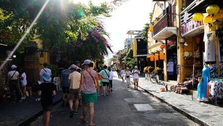 Group of family travellers walking through the street markets in Hoi An, Vietnam