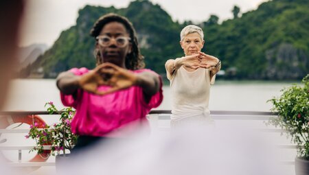 Intrepid travellers do some tai chi on a boat in Ha Long Bay