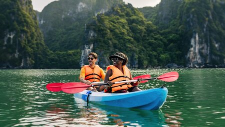 Intrepid travellers pause to take in the majesty of Ha Long Bay while kayaking