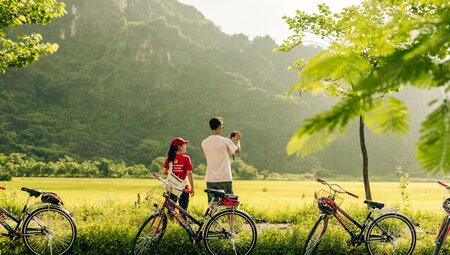 Intrepid traveller and leader stop for a photo of green hilled landscape