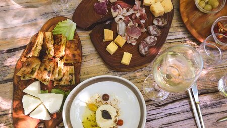 Plates of cured meats, cheese, and artisinal breads and wine at Mrizi i Zanave in Albania