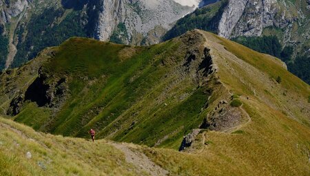 Traveller with hiking sticks goes up the Volusnica loop trail in Albania's Prokletije National Park