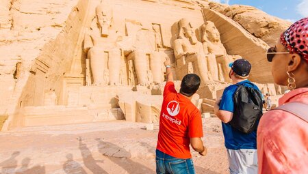 Traveller points out details on the front of Abu Simbel temples in Egypt
