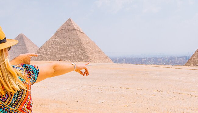 Two travellers look out over the Gisa Pyramids, Egypt