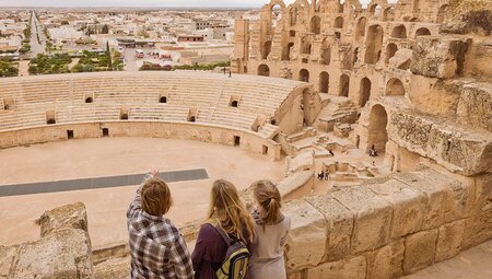 Family looks over Roman colliseum ruins, El Jem, Tunisia