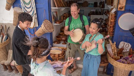 Family having fun with instruments in Essaouira market, Morocco
