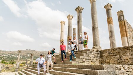 Group of Intrepid travellers pose at Volubilis ruins in Morocco