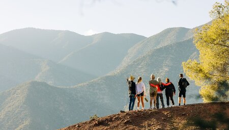 Intrepid travellers and leader take in the view of Atlas Mountains in Morocco