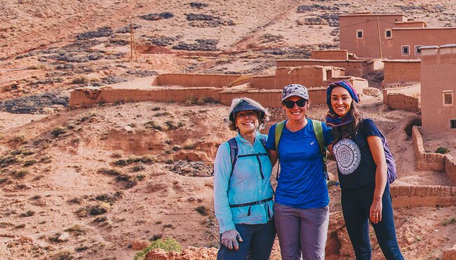 Group of travellers standing before Ait Benhaddou fortified village, Morocco