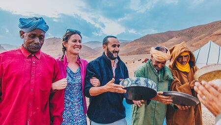 Travellers and local berbers at desert camp, Sahara, Morocco