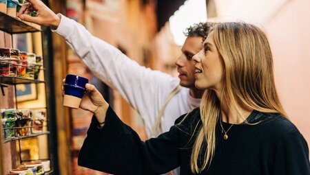 Intrepid travellers look at ceramics in a small shop in the Marrakech Market Bazaar, Morocco