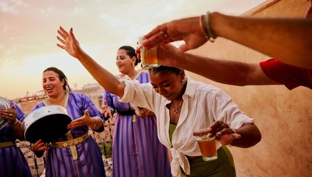Traveller dancing to locals playing live music, Marrakech, Morocco