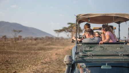 Travellers on board Safari vehicle in the Serengeti