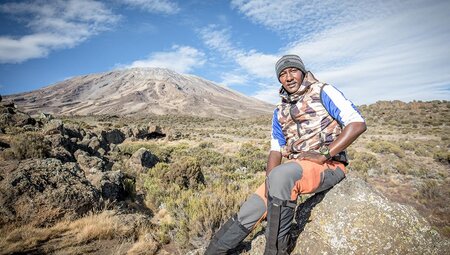 Intrepid tour leader looking out over the summit of Mt Kiliminjaro, Tanzania