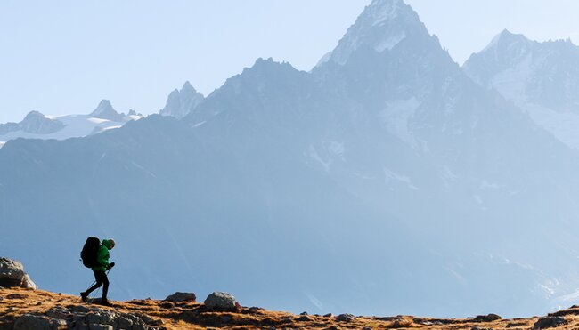 Hiker trekking with Mont Blanc mountain range in the background