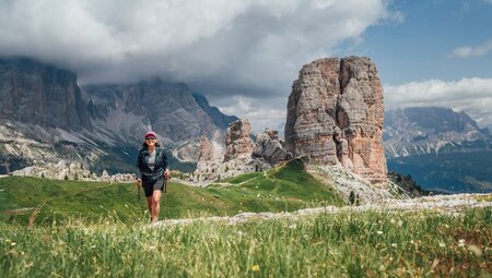 Intrepid traveller crests a hill trekking Cinque Torri near Cortina d'Ampezzo in Italy's Dolomite mountains